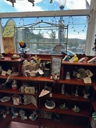 Annetta Lawson's Ned Lawless Studio Booth 69 — full display of curiosities and collectibles with string lights