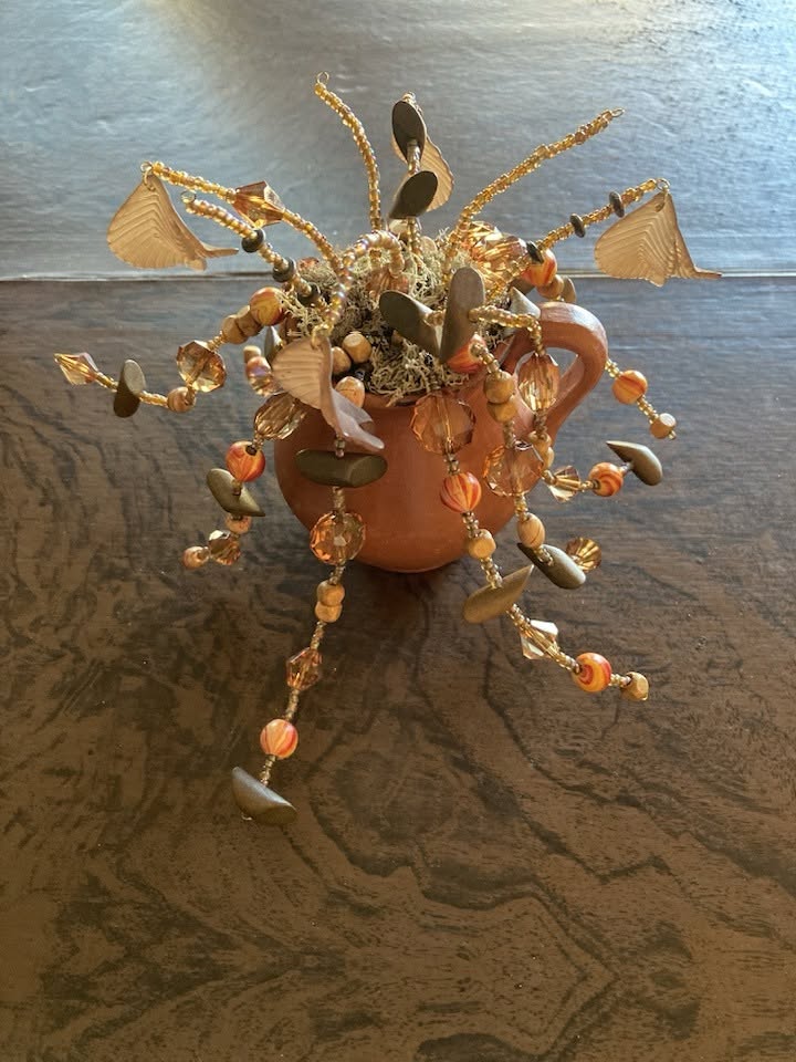One-of-a-kind beaded terracotta art piece with crystals, seed beads, and hand-formed elements — artisan treasures at Maudie's